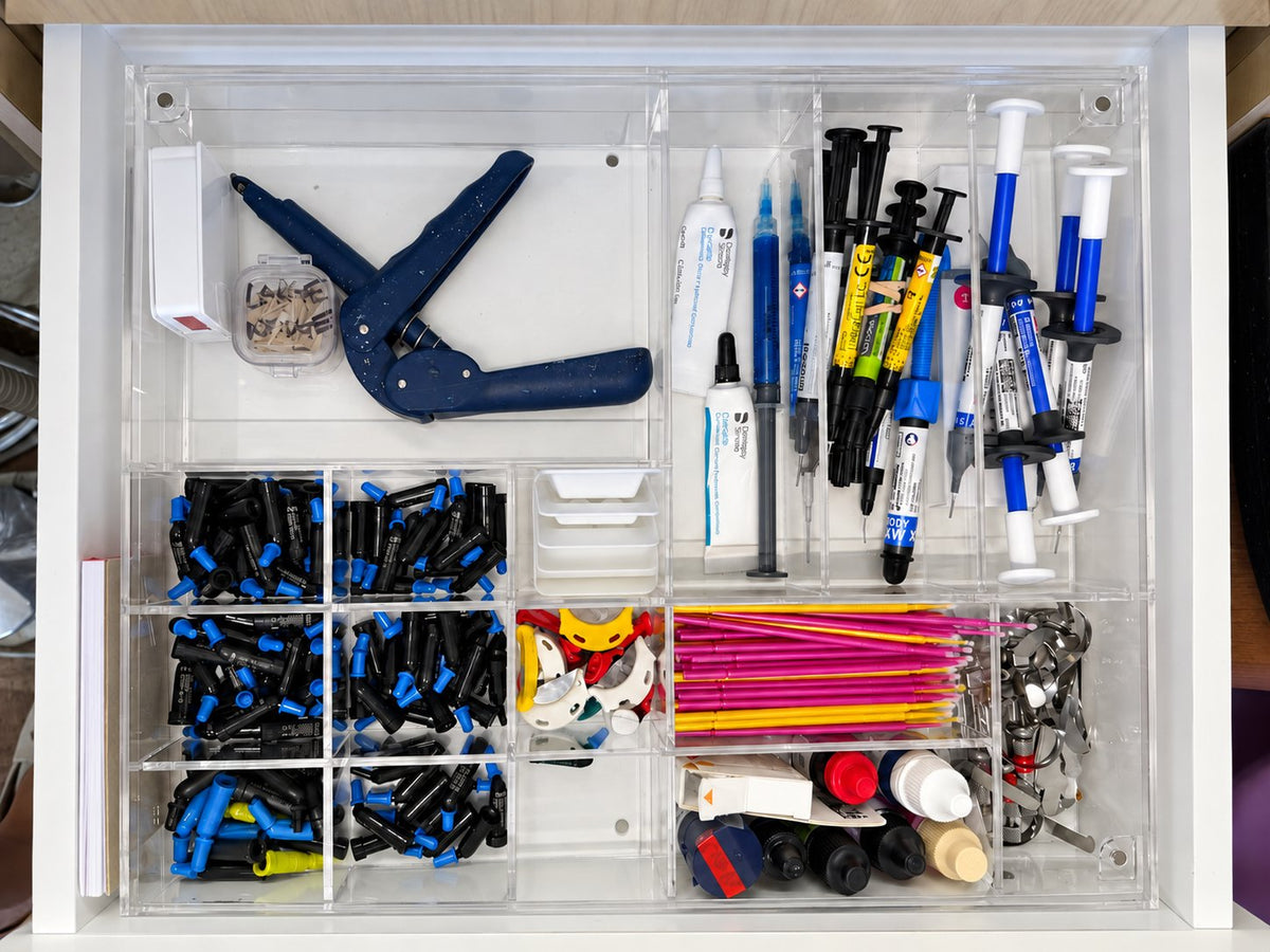 Restorative dental materials organized in clear acrylic drawer compartments
